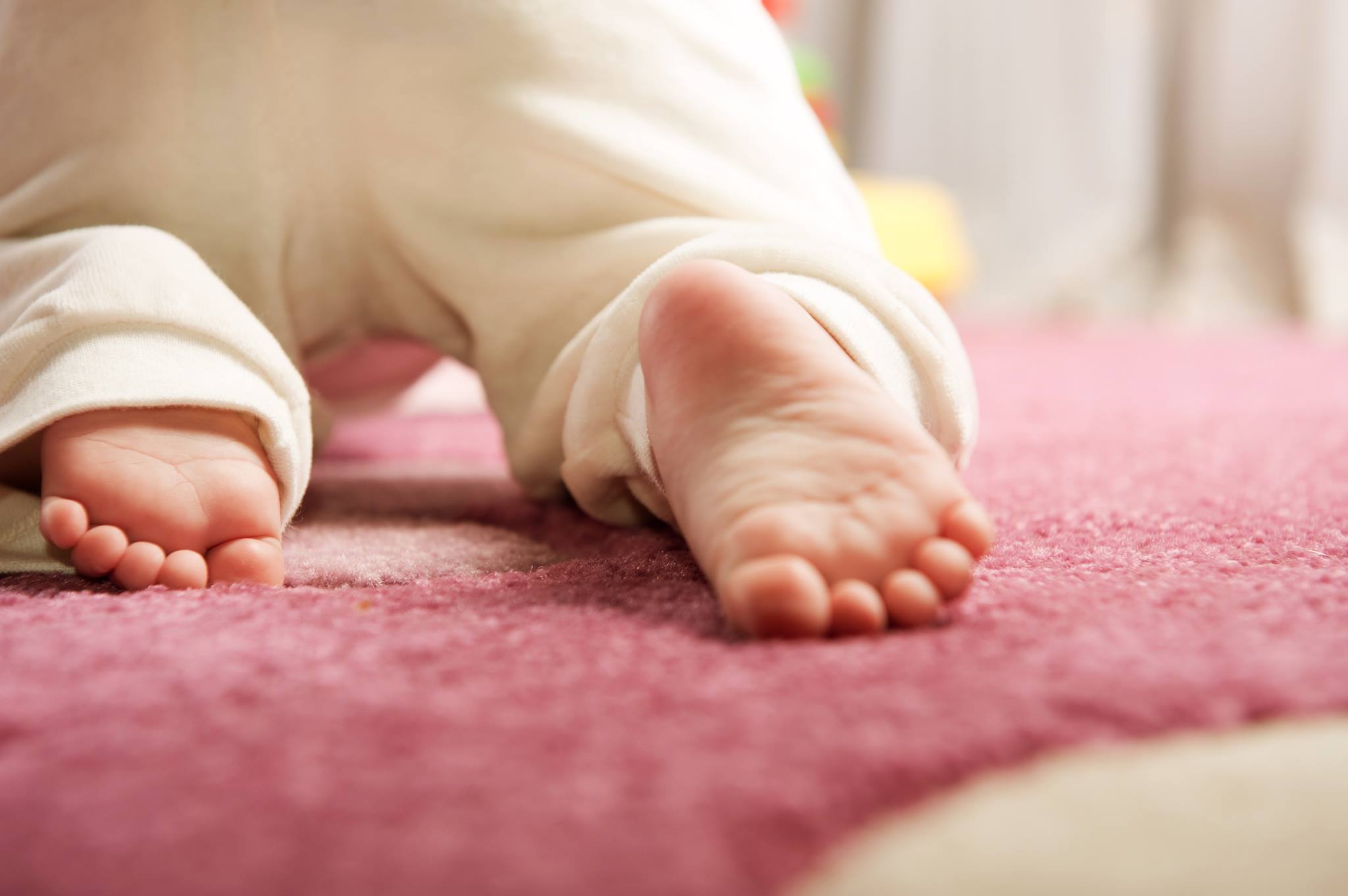 Ножки в 6 месяцев. Ноги младенца. Младенец ползает. Стопы детей девочек. Детские ножки на ковре.
